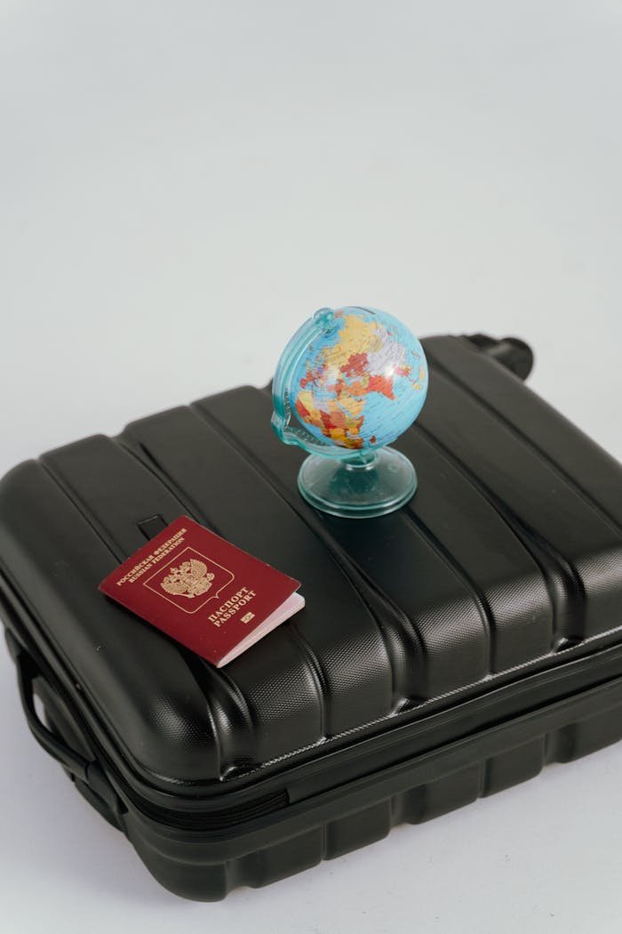 creative A passport, luggage, and mini globe symbolize travel planning and wanderlust.